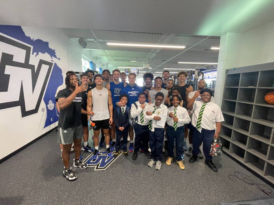 Charter school students posing with GVSU athletes